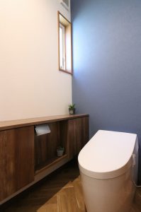 トイレにもヘリンボーンの床を採用。 深い藍色のアクセントクロスでクラシカルで上品な雰囲気に。