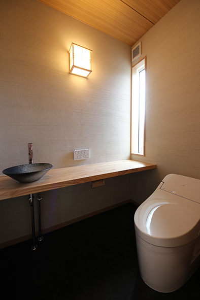 手洗いを造作で仕上げた和のテイストのトイレ。壁は薩摩中霧島。
