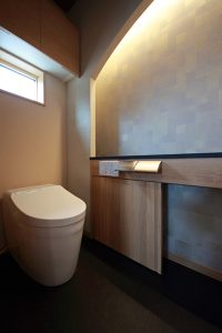 和室の床の間などにも取り入れられることの多い、アーチの下がり壁に間接照明を入れた和モダンのトイレ。